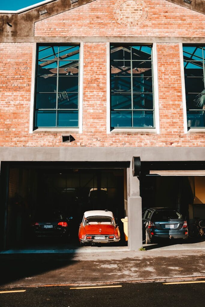 A modern brick building exterior with cars parked in the garage, showcasing urban architectural design.